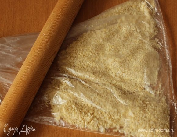 При помощи скалки измельчить миндальные лепестки в крошку.