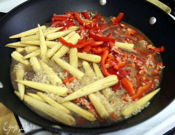 Теперь кладем рис, красный перец (нарезанный соломкой) и кукурузу. Наливаем бульон или воду (чтобы покрыло) и тушим при закрытой крышки и медленном огне до готовности риса.