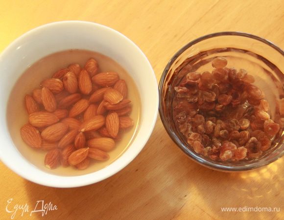 Замочите в кипятке изюм и миндаль (в разной посуде).