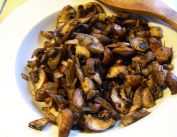 Разогрейте 1 ст. л. оливкового масла и обжарьте лук и грибы без крышки минут 12–15 до испарения всей жидкости. Переложите смесь в отдельную тарелку.