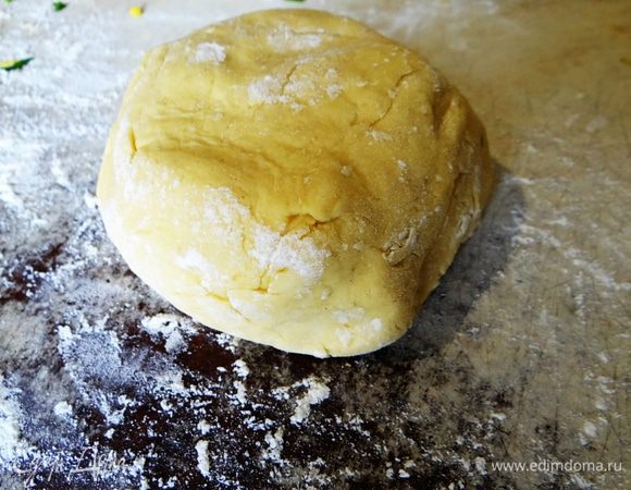 Остальную муку всыпать на стол, выложить шарик теста. Немного его помяв, постепенно добавлять столько муки, сколько тесто сможет взять. Оно не должно быть слишком крутым или слишком мягким. Завернуть тесто в пакет или пленку, положить на 30 минут в холодильник.