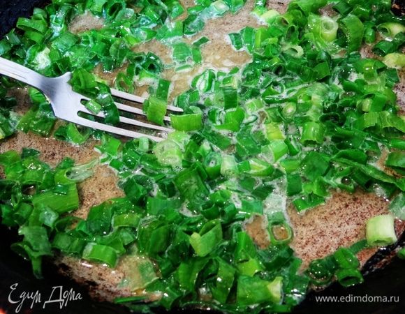 Добавить к маслу зеленый лук, перемешать. Готовить на небольшом огне пару минут.