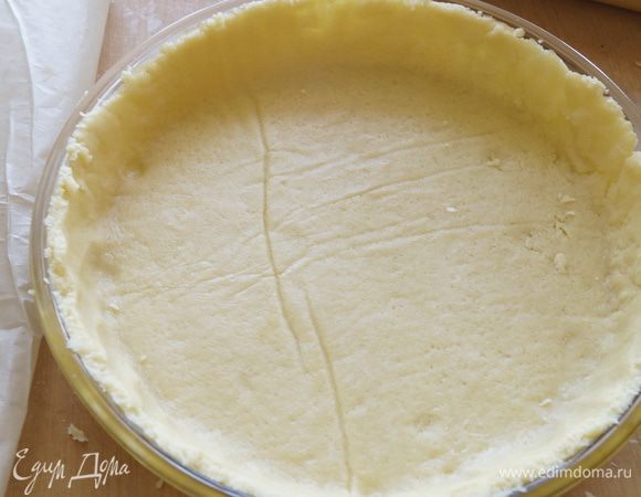 Из холодильника достаем тесто и раскатываем его между двумя листами бумаги. Выкладываем в форму для выпечки, застилаем сверху бумагой и насыпаем на бумагу например горох или фасоль. Ставим выпекаться в разогретую до 190 градусов духовку на 15 минут.