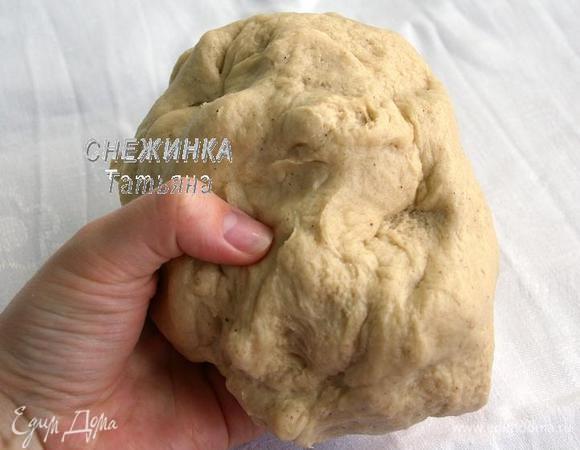Перемешиваем всё и замешиваем однородное тесто. Затем рабочую поверхность подпыляем мукой и вымешиваем тесто руками 10 минут, чтобы оно стало эластичным. По необходимости добавляйте по щепотке муки, если чувствуете, что тесто ещё слишком мягкое.

