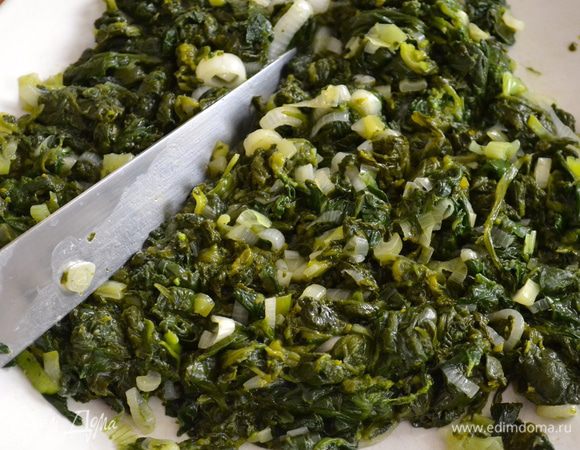 Удалить лишнюю жидкость, переложив содержимое сковороды в дуршлаг. Переложите шпинат и порубите ножом. 