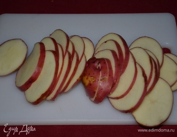 Смазать  форму растительным или оливковым маслом. Порезать тонко красный картофель.  Затем лимон крупный тонко кольцами.