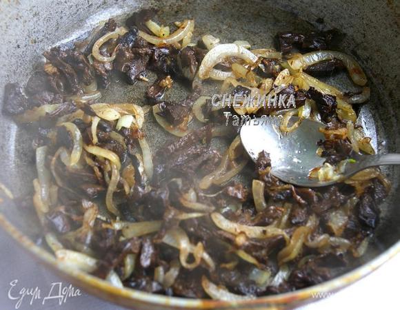 На сковороде разогреваем растительное масло, кладём лук и жарим до золотистого цвета. Теперь добавляем нарезанные грибы и жарим ещё пару минут. 