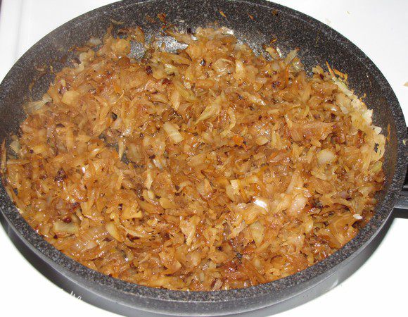 Добавьте в сковороду квашеную капусту, премешайте  и тушите под крышкой 10 минут. Откройте крышку, выпарите всю жидкость.