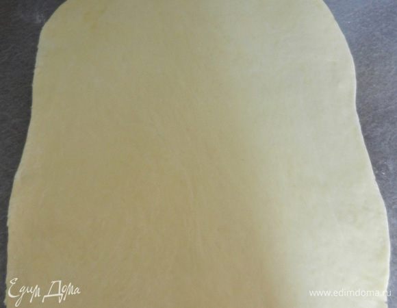 Когда тесто подошло, раскатайте из него корж размером немного больше, чем форма для выпечки. У меня форма для выпечки размером 33х23х5 см. Для сравнения прикладывайте эту форму сверху.