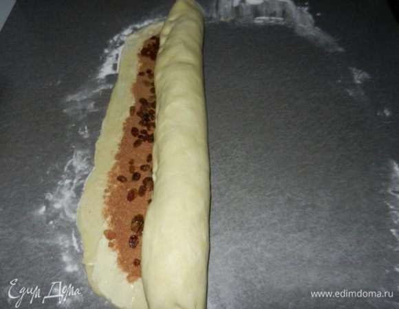 Начиная со стороны, которая длиннее, начинаем скатывать тесто в рулетик. Старайтесь делать его плотным и скатывать с обеих сторон равномерно. Конец рулета смазать водой, чтобы он не раскрылся, закрутить.
