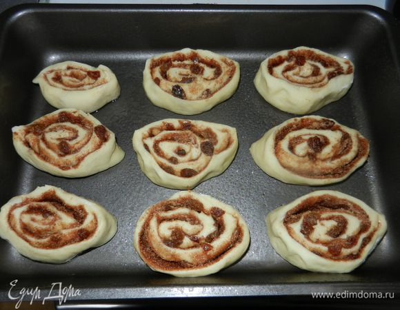 Полученные части разрезанного рулета выкладывать на бок на хорошо смазанную мягким маслом форму для выпекания. Оставляйте между ними небольшой интервал, так как они подойдут и увеличатся в размере. Теперь накройте пленкой и оставьте подойти на 1,5 часа в теплом месте.
Включите духовку на 180 градусов Цельсия для разогрева.