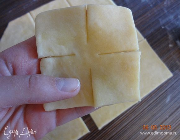 Отдохнувшее тесто раскатать в пласт (1-2 мм), вырезать квадрат, затем разрезать на маленькие квадратики (со стороной 10 см), сделать надрезы со всех сторон.