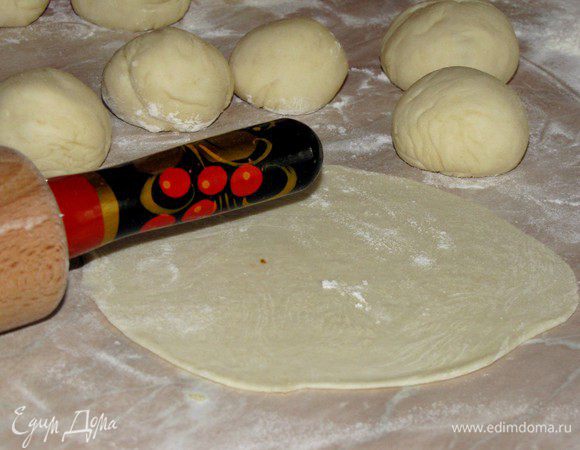 Поднявшееся тесто обмять, несколько раз ударить им по столу.  Разделить тесто на 12 равных частей.Раскатать каждую часть в очень тонкую круглую лепешку.