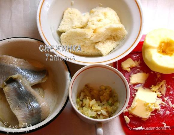 Подготовим все продукты для начинки. Селёдку режем крупными кусочками. Лук чистим, моем, нарезаем кубиком и обжариваем до мягкости на растительном масле. Белый хлеб заливаем небольшим количеством воды, чтобы он размок. Чистим яблоко от кожи и семян.