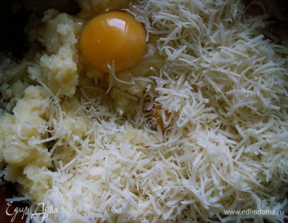 Картофель немного остудить, очистить и размять вручную. Добавляем к пюре яйца (оставшиеся 2 яйца спрятались под сыром), сыр (пару ложек сыра оставляем), соль и перец (я использовала белый) и тщательно все перемешиваем.