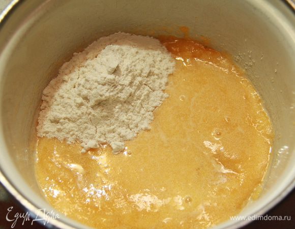 Приготовьте заварной крем. Взбейте желтки с сахаром добела. Добавьте муку и перемешайте. 