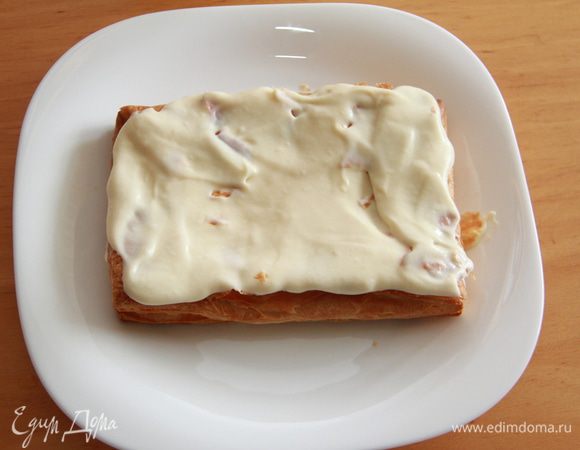 Сборка торта. Слегка прижмите нижний корж, чтобы он немного осел. Намажьте 1/4 объёма крема на корж. 