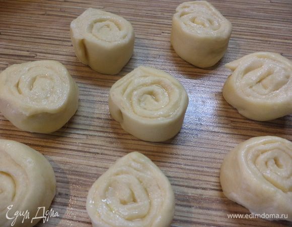 Сверните рулет и разрежьте на части шириной 2–2,5 см, накройте полотенцем и оставьте на расстойку, а тем временем займитесь картошкой и луком.