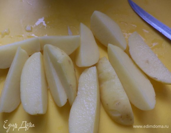 Пока жарится лук, очистите картошку и нарежьте на половинки или четвертинки, если она крупная.