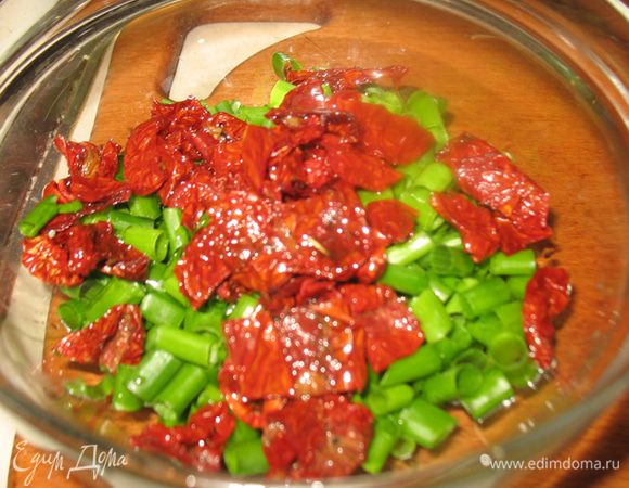 Зеленый лук режем небольшими кусочками, вяленые помидоры разрезам пополам. 