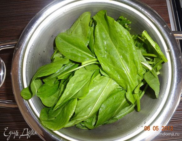 За это время приготовить начинку. Щавель хорошо промыть и обсушить, отрезать стебли наполовину. Можно сложить в дуршлаг и обдать кипятком или потушить в сотейнике 5-7 минут на слабом огне, щавель станет бурым и уменьшится в 3-4 раза в объеме.