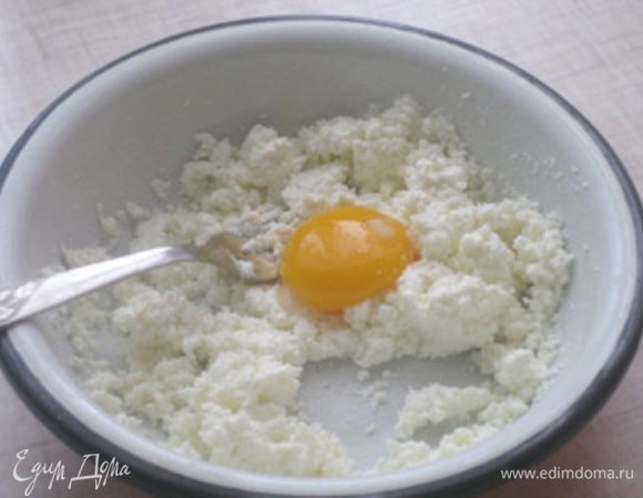 Творог размять вилочкой, яйцо разделить не белок и желток. Добавить желток к творогу.