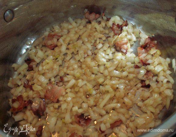 В кастрюле с толстым дном обжариваем бекон на 1 ст. ложке растительного масла. Добавляем лук и обжариваем вместе с беконом до золотистого цвета.