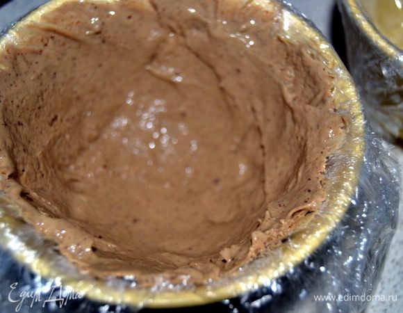 Достаем из морозилки форму и темное мороженое.Выкладываем его в форму делая углубление в низу и формируем бортики.Убираем в морозилку.