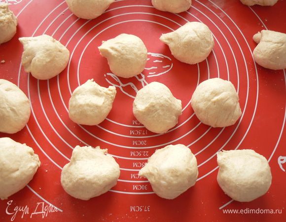 выброженное тесто разделить на 16-20 булочек, уложить на бумагу для выпечки, накрыть пленкой, оставить на 40 мин для расстойки