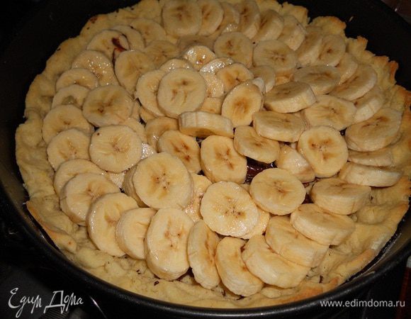 Бананы нарезать, сбрызнуть лимонным соком и уложить сверху на шоколад.