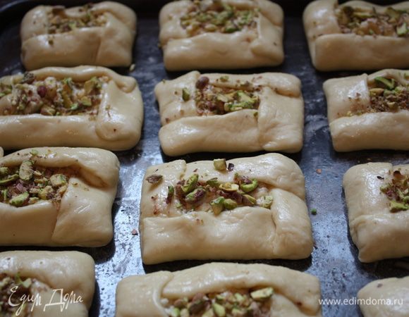 Пирожки выкладываем на противень, слегка посыпанный мукой или на пергамент, смазываем желтком и даем постоять 15-20 минут. Затем посыпаем оставшимися орешками и отправляем в духовку, разогретую до 180 градусов на 25-30 минут.