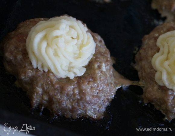 Котлетки достаем из духовки, в углубление кладем небольшой кусочек сыра, а сверху отсаживаем картофельное пюре с помощью кондитерского мешка или ложки, сами котлетки поливаем немного соусом и ставим в духовку еще минут на 10 (до появления золотистой корочки на картофельном пюре)