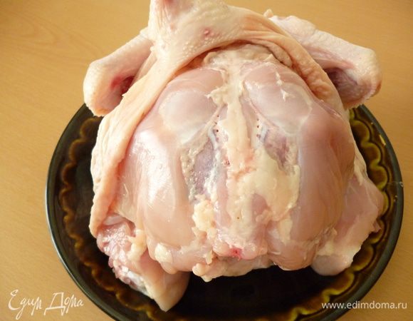Переверните тушку курицы спинкой вверх и снова аккуратно отделите кожу. Крылышки оставьте целыми, отсоедините их с помощью ножа.
