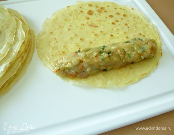 Испеките несладкие блинчики. Можете приготовить их по своему любимому рецепту. Нам их понадобится 8–10 штук. Все зависит от величины самой курицы и толщины блинного рулетика. На край блинчика выложите фарш.