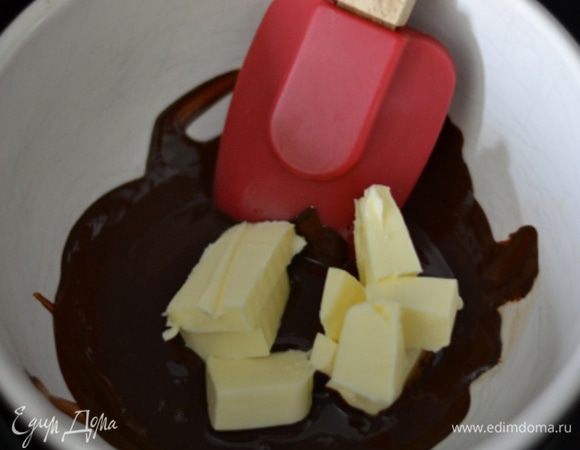 Добавить масло, нарезанное маленькими кусочками. Как только масло растопилось, убрать с бани.