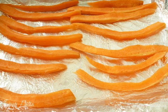 В форму для запекания выкладываем двойной слой пергамента или фольги. Затем брусочки почищенной моркови,что бы курица не подгорала и кожа не прилипла во время запекания.