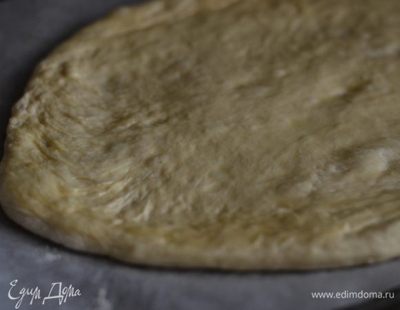 Присыпьте немного муки на тесто, руками сформируйте большой овал. Кисточкой смазать слегка оливковым маслом.