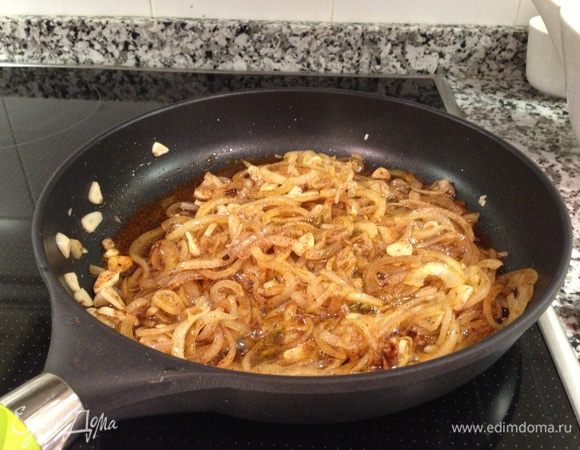 В сковороде, сотейнике или широкой низкой кастрюле разогреть оливковое масло. Выложить мелко нарезанный чеснок и порезанный полукольцами лук. Обжаривать на медленном огне, до мягкости. Добавить паприку и продолжать готовить 2-3 минуты..