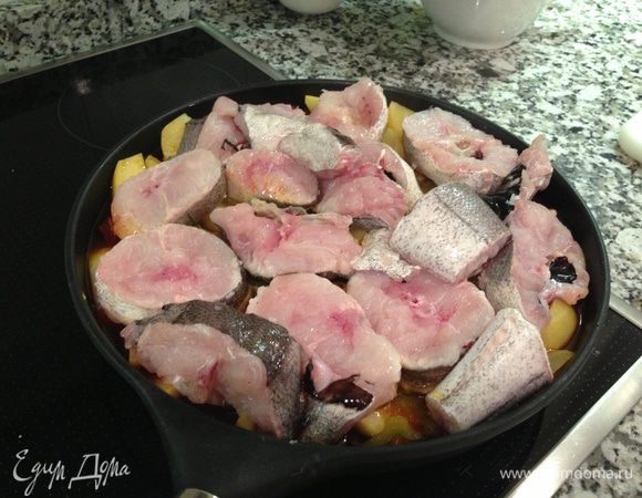 Кусочки рыбы (в оригинале стейки хека) приправить по вкусу, я только посолила, выложить в сковороду на картофель,  накрыть крышкой и тушить 10-15 минут, до готовности рыбы.