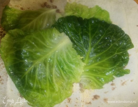 поверх мяса выложить листы капусты