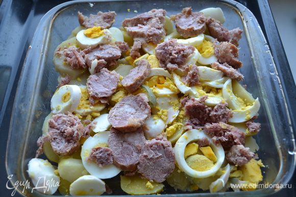 Форму для запекания смазываем растительным маслом. Поочередно укладываем слой картофеля, яиц и колбасы.