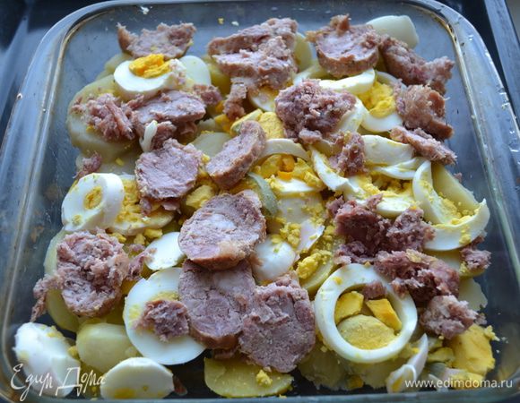 Форму для запекания смазываем растительным маслом. Поочередно укладываем слой картофеля, яиц и колбасы.
