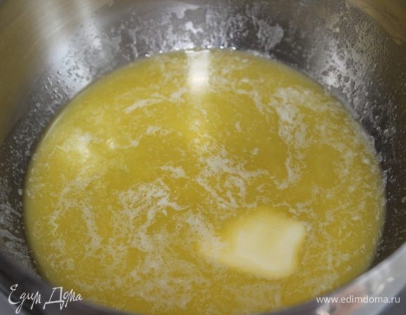 Сливочное масло растопить на слабом огне. Влить к маслу 200 г воды.