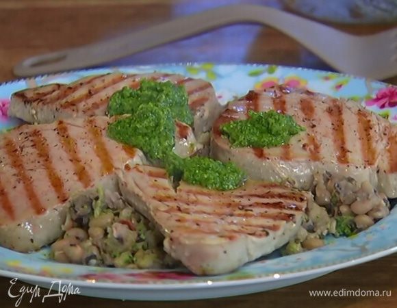На рыбные стейки выложить понемногу соуса песто, посыпать оставшейся петрушкой и подавать с фасолью и кусочками лимона.