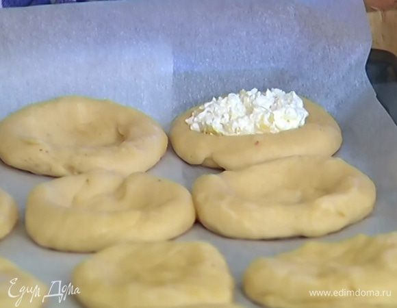 Сделать в середине каждой лепешки углубление и разложить творожную начинку.
