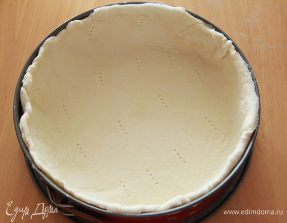 Тесто раскатать и выложить в форму, прижать по бортам, проколоть тесто вилкой.