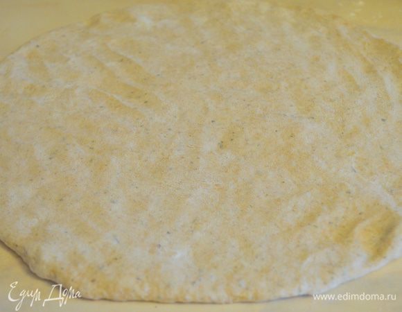на присыпанном мукой столе, руками расплющиваем тесто в лепешку, толщиной 0,5-0,7 см 