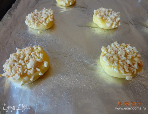 Смазать поверхность печенья желтком и макнуть этой стороной в молотые орехи, выложить на лист, застеленный бумагой и отправить в разогретую духовку на 15 минут.