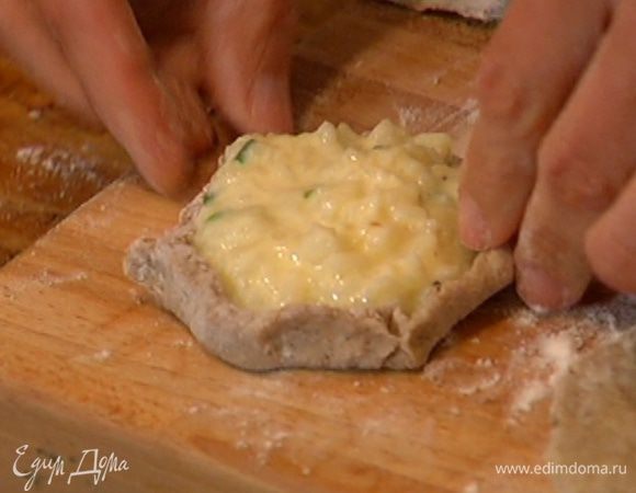 Сформировать руками из кружков теста небольшие лепешки, в центр выложить начинку и сделать бортики.