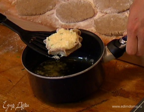 Каждую лепешку поместить на шумовку, окунуть бортики в растопленное масло, затем выложить пирожки на противень.